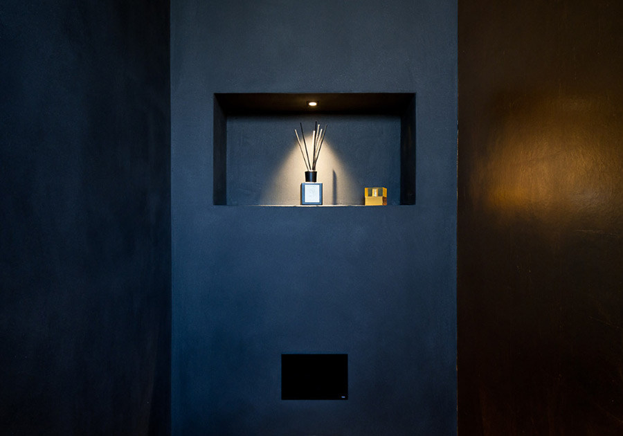 Dunkel gestaltete Wand mit Nische und indirekter Beleuchtung