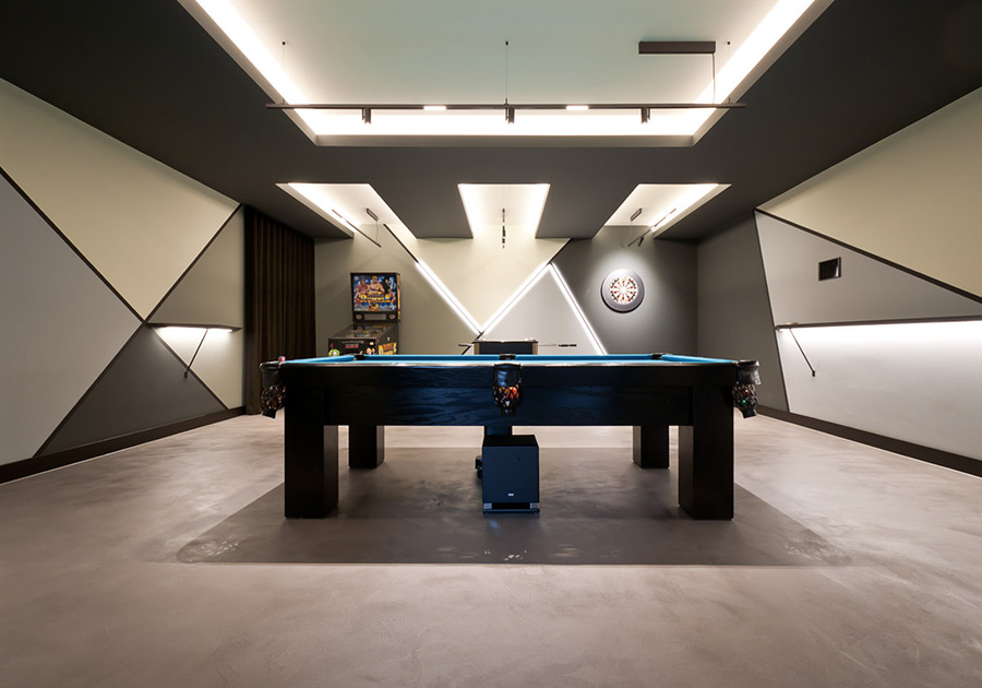 Billardzimmer mit geometrischer Lichtdecke und Wandgestaltung in Grau