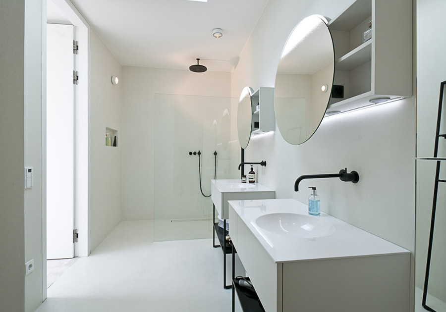 Weißes Bad mit runden Spiegeln, Glasdusche und schwarzer Armatur