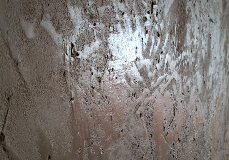 Dunkle, strukturierte Wand mit markanter Spachteltechnik und Tiefenwirkung